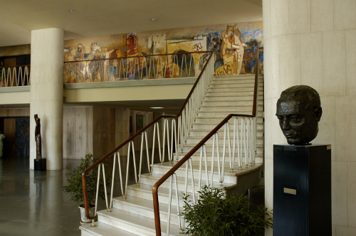 Stairs to the Library floor showing the wall mural by M.F. Hussain; the bust of Homi Bhabha can be seen on the right. TIFR Archives