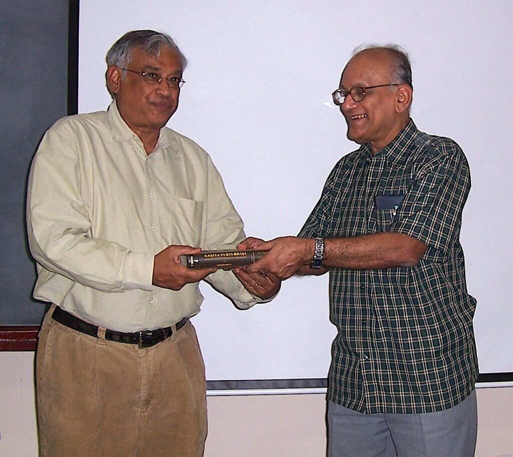 SRS Varadhan receiving a copy of Gaṇita-Yukti-Bhāṣā from Seshadri