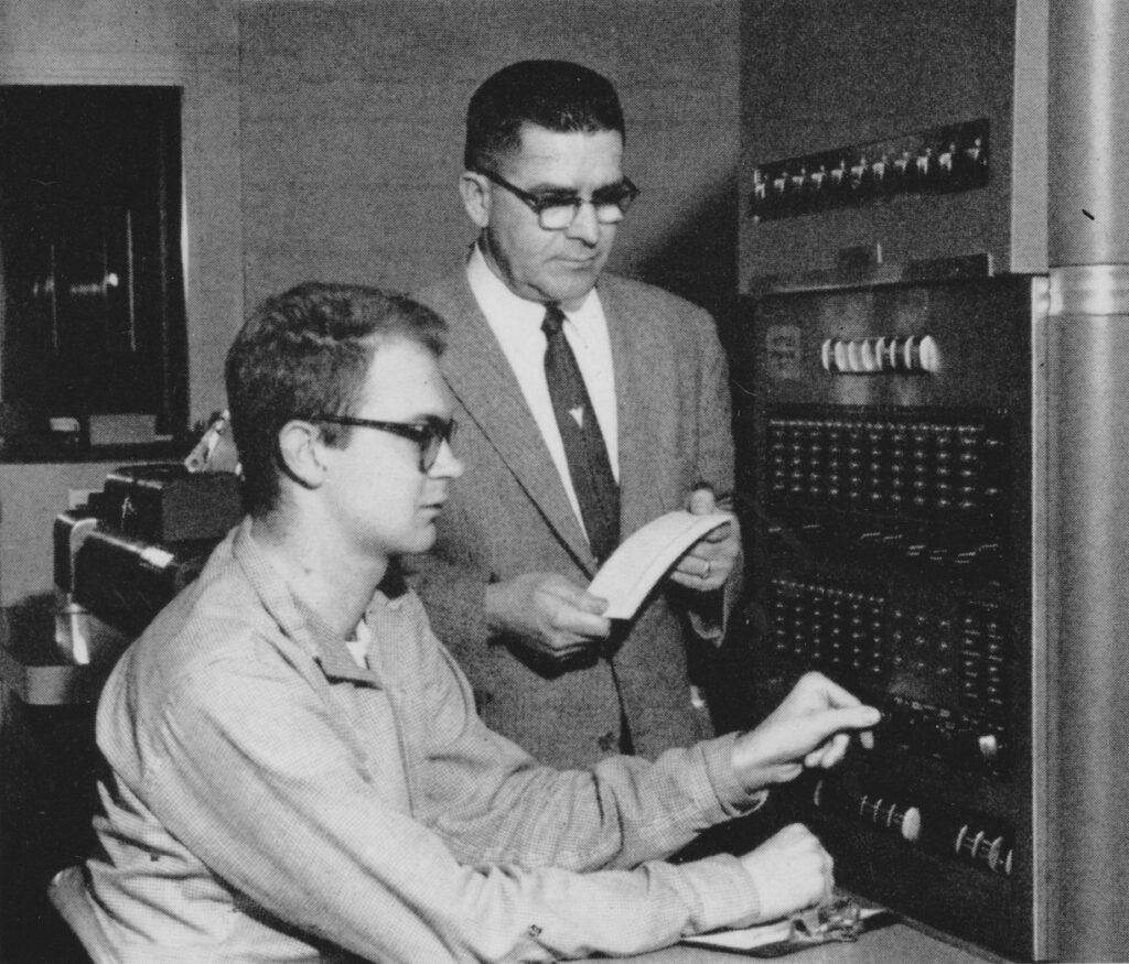 At the console of the IBM 650 at Case, with basketball coach Heim; 1960