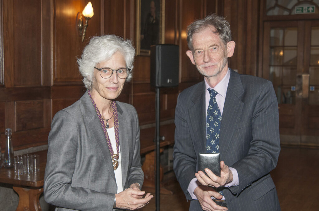 Sir John Ball receiving the prestigious De Morgan Medal from Ulrike Tillmann, President of the London Mathematical Society.